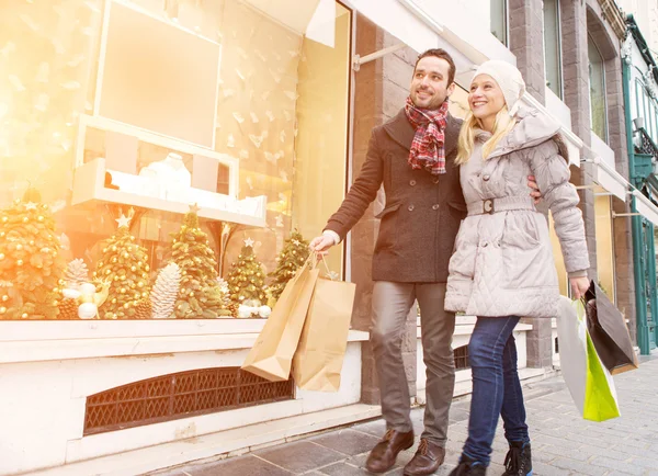 Joven pareja atractiva haciendo algunas compras ventana — Foto de Stock