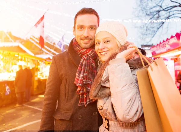 Young attractive couple in a christmas market — Stock Photo, Image