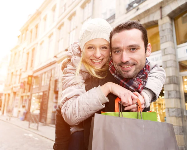 Jovem casal atraente com sacos de compras — Fotografia de Stock