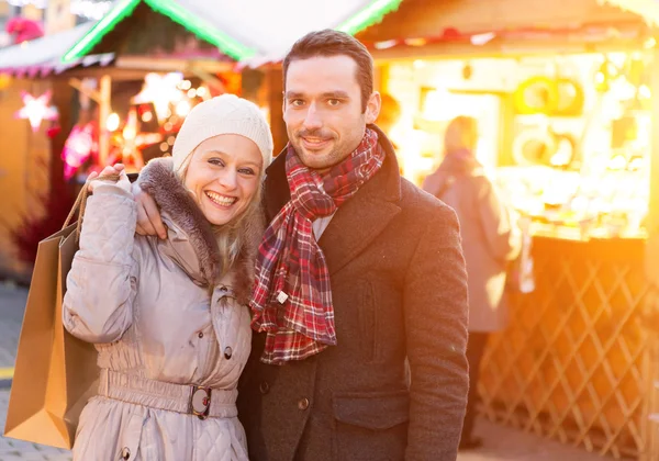 Young attractive couple in a christmas market — Stock Photo, Image