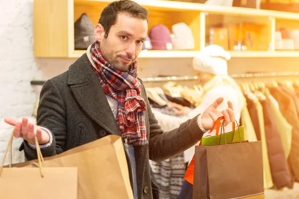 Casual jongeman wachten terwijl zijn vrouw het winkelen — Stockfoto