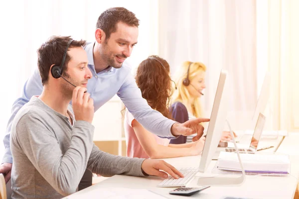 Manager training a young attractive people on computer — Stock Photo, Image