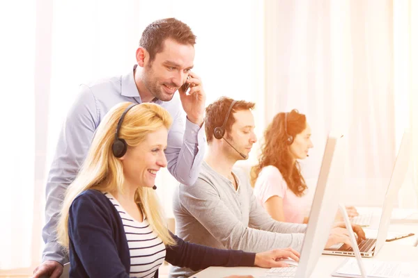 Manager training een aantrekkelijke jongeren op computer — Stockfoto