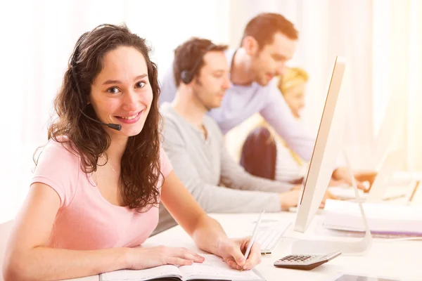 Jonge aantrekkelijke vrouw die werkt in een callcenter — Stockfoto