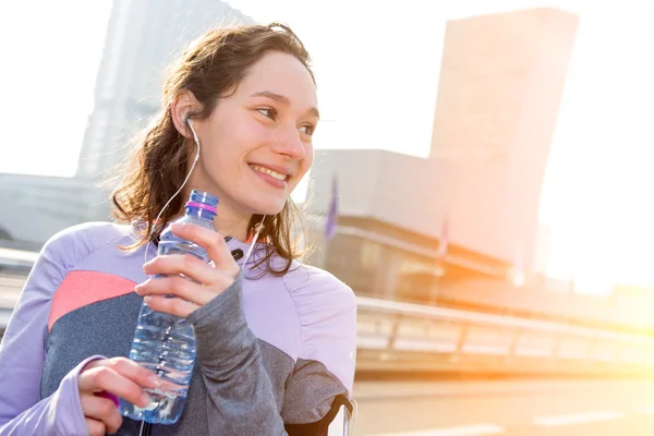 Donna che beve acqua durante una sessione di corsa — Foto Stock