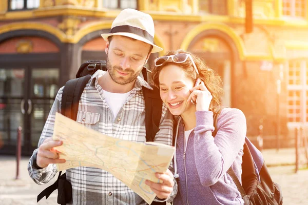 Couple of young attractive tourists watching map — Stock Photo, Image