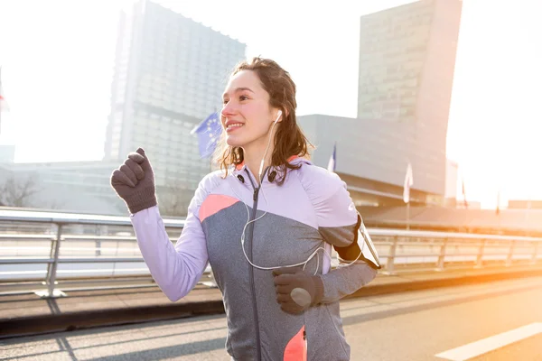 Jeune femme attrayante courir en ville — Photo