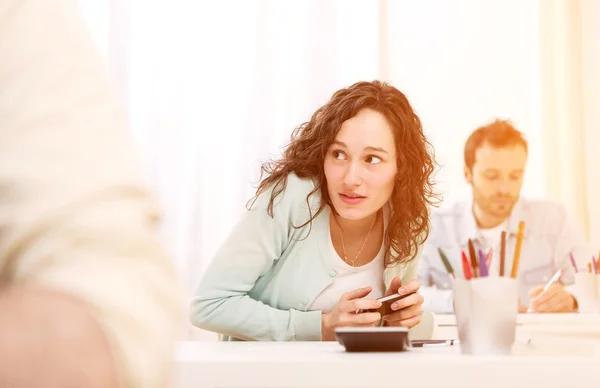 Junge attraktive Frau betrügt mit Handy während der Prüfung — Stockfoto