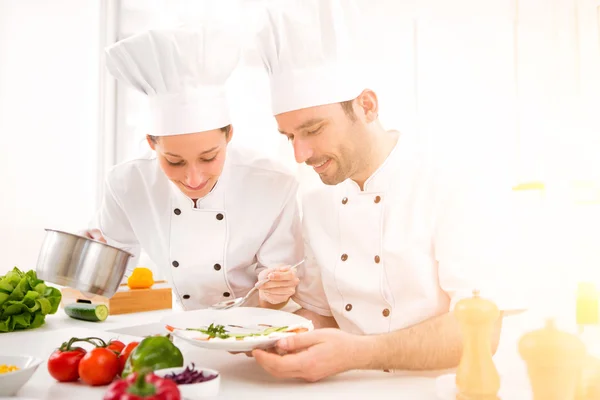 Jovens atrativos profissionais chefs cozinhar juntos — Fotografia de Stock