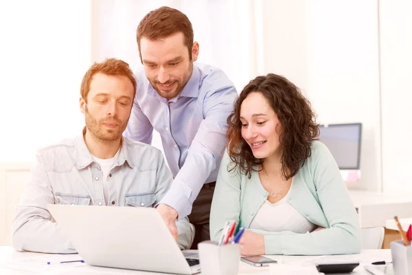 Twee stagiairs werken samen bijgestaan door hun cursus toezichthouder — Stockfoto