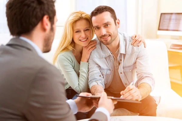 Agente imobiliário presente projeto em tablet para um jovem casal — Fotografia de Stock