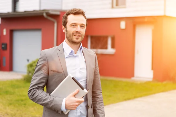 Portrait of a young real estate agent in front of a house — Stock Photo, Image