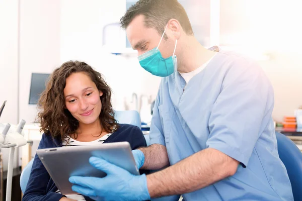 Joven mujer atractiva siendo curada por un dentista — Foto de Stock