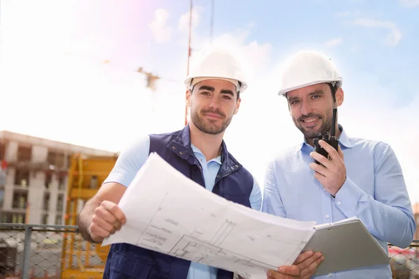 Arbetare och arkitekt tittar några detaljer på en konstruktion — Stockfoto