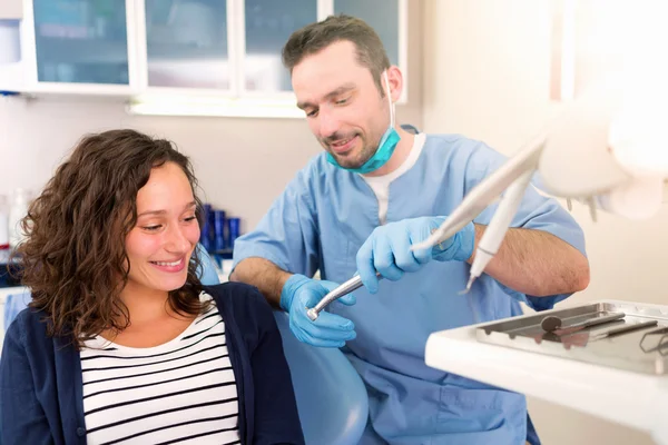 Young attractive woman being cured by a dentist — Stock Photo, Image