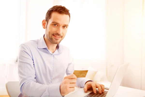 Jonge zakenman thuis werken op zijn laptop — Stockfoto