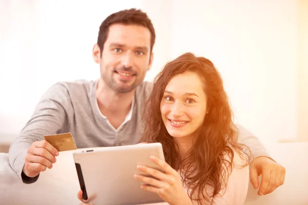快乐的年轻夫妇，在平板电脑上冲浪 — 图库照片