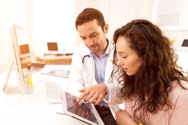 Médico que utiliza o comprimido para informar o doente — Fotografia de Stock