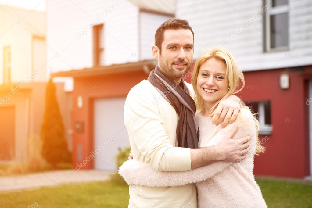 Young happy couple in front of their new house