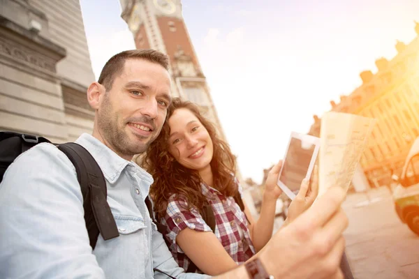 Couple of young attractive tourists watching map — Stock Photo, Image