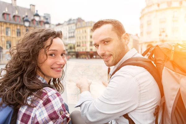 Couple of young attractive tourists watching map — Stock Photo, Image