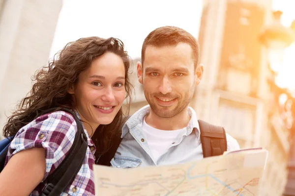 Couple of young attractive tourists watching map — Stock Photo, Image