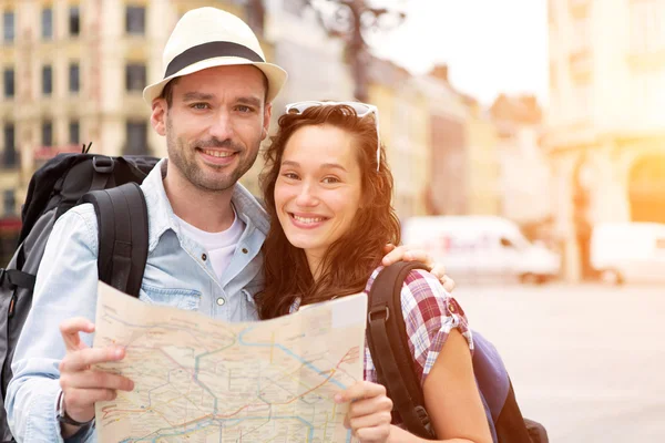 Couple of young attractive tourists watching map — Stock Photo, Image