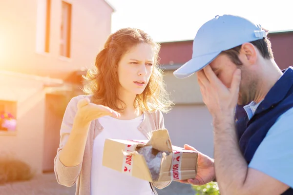 Young attractive woman receiving parcel at home — Stock Photo, Image