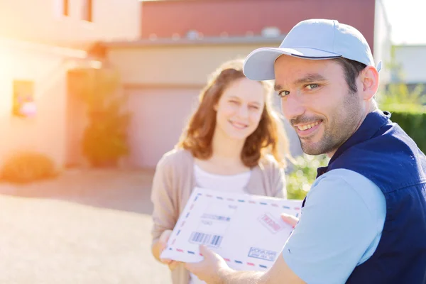 Young attractive woman receiving parcel at home — Stock Photo, Image