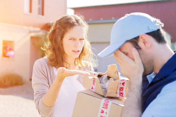 Young attractive woman receiving parcel at home — Stock Photo, Image