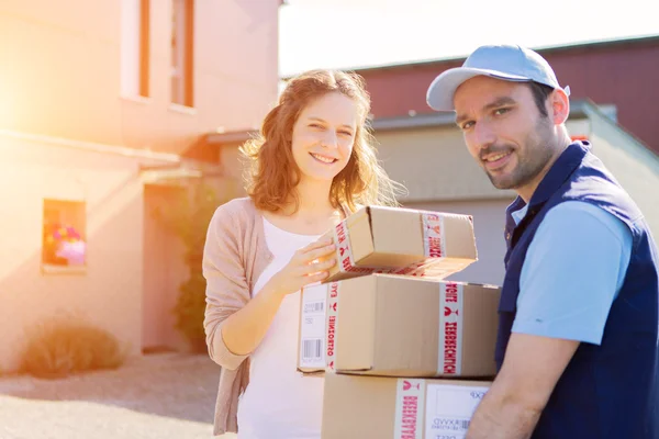 Young attractive woman receiving parcel at home — Stock Photo, Image