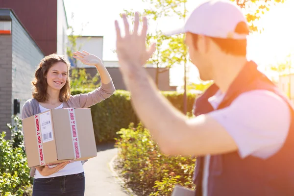 Young attractive woman receiving parcel at home — Stock Photo, Image