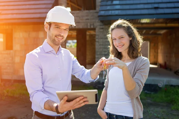 Mujer joven y arquitecto en obra — Foto de Stock