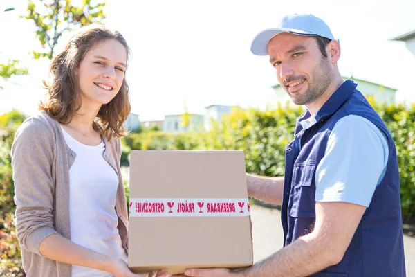 Junge attraktive Frau erhält Paket zu Hause — Stockfoto