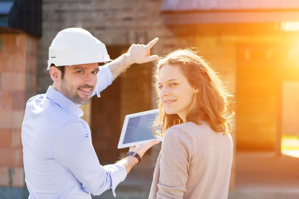 Mujer joven y arquitecto en obra — Foto de Stock