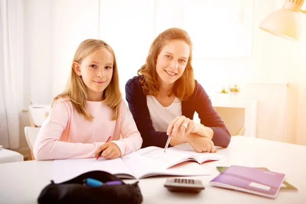 Femme aidant sa petite sœur pour les devoirs — Photo