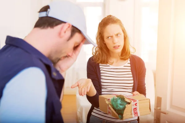 Delivery man handing over a parcel to customer — Stock Photo, Image
