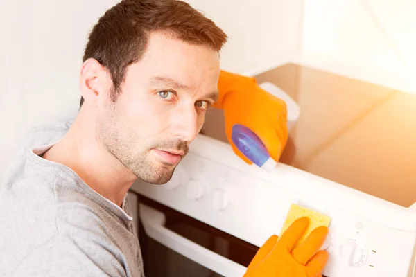 Молодой привлекательный мужчина убирает свою квартиру — стоковое фото