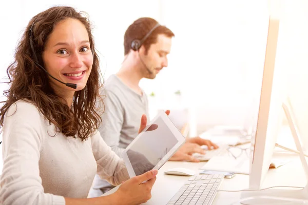 Giovane donna attraente che lavora in un call center — Foto Stock