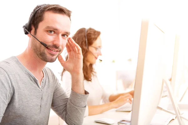 Jovem homem atraente trabalhando em um call center — Fotografia de Stock
