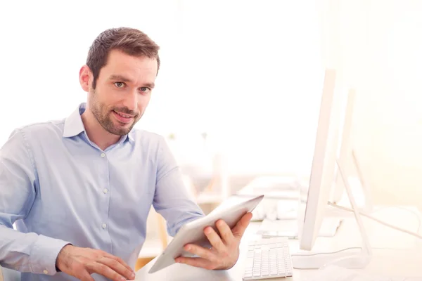 Giovane uomo attraente con tablet in ufficio — Foto Stock