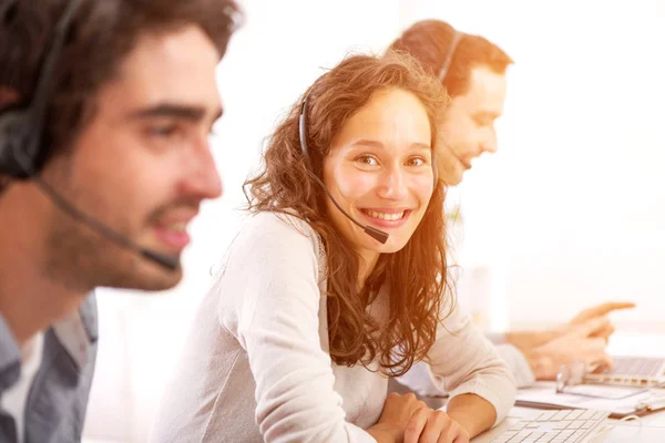 Jonge aantrekkelijke vrouw die werkt in een callcenter — Stockfoto