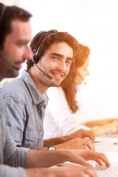 Giovane uomo attraente che lavora in un call center — Foto Stock