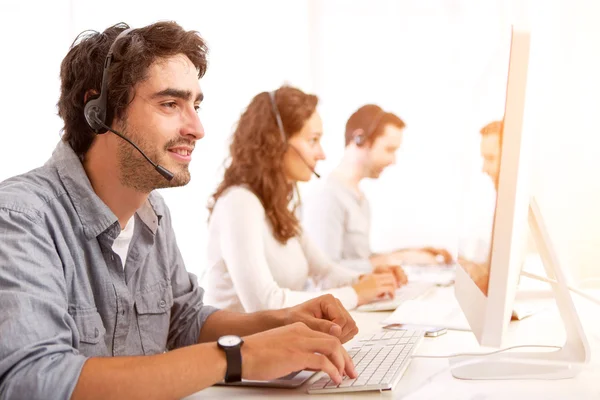 Aantrekkelijke jongeman werken in een callcenter — Stockfoto
