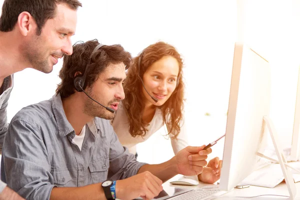 Group of people working around a computer — Stock Photo, Image