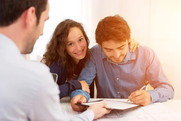 Jovem atraente casal assinatura contrato — Fotografia de Stock