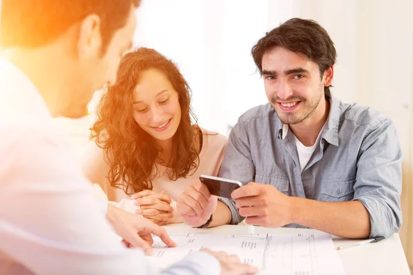Young attractive couple signing contract — Stock Photo, Image