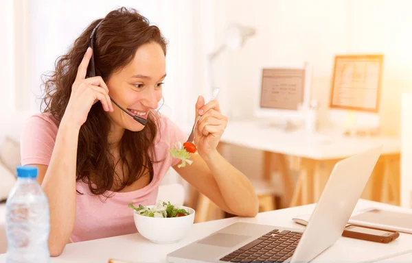 Giovane studente attraente mangiare mentre si lavora — Foto Stock