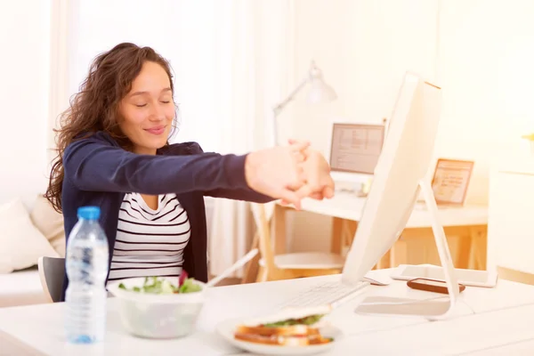 Jovem estudante atraente comer enquanto trabalhava — Fotografia de Stock