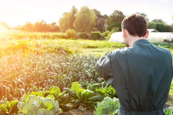 Unga attratcive bonden framför trädgård — Stockfoto